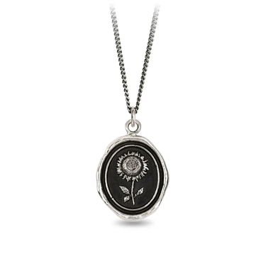 A Sterling Silver Pyrrha Talisman With a black background depicting a Large Upright Sunflower
