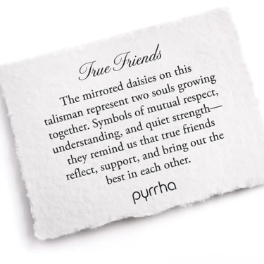 A Pyrrha note describing the True Friends talisman. It reads, "The mirrored daisies on this talisman represent two souls growing together. Symbols of mutual respect, understanding, and quiet strength—they remind us that true friends reflect, support, and bring out the best in each other."