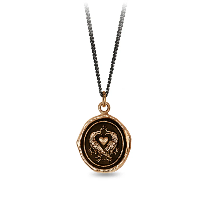 Bronze Necklace featuring a talisman depicting 2 crows crossing eachother with a heart between them and their beaks connected by a ring 