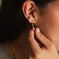 14k yellow Gold drop earrings with a leverback mechanism that allows for gold beads to be moveable. connected to the earring is two more beads encompassing a white pearl | on model