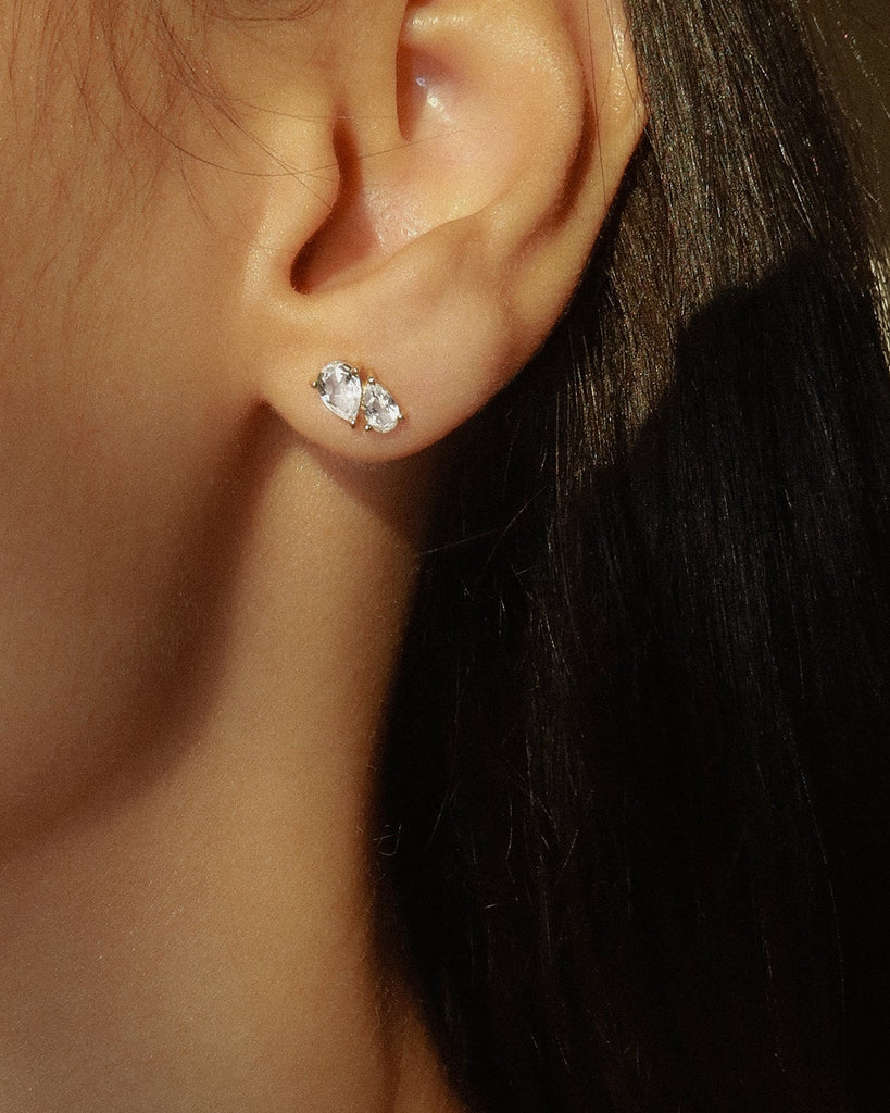 14k Yellow gold plated sterling silver studs  with a pear cut white topaz gemstone  | on model