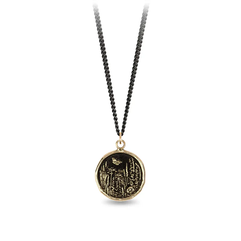 Black Sterling Silver Necklace with a 14k yellow gold talisman depicting a Butterfly flying over a field of varying flora and plants