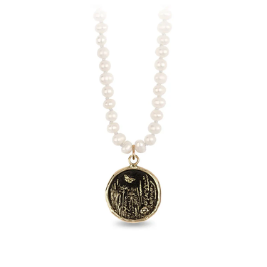 Knotted ivory freshwater pearl necklace with a 14k Yellow gold talisman depicting a Butterfly flying over a field of varying flora and plants