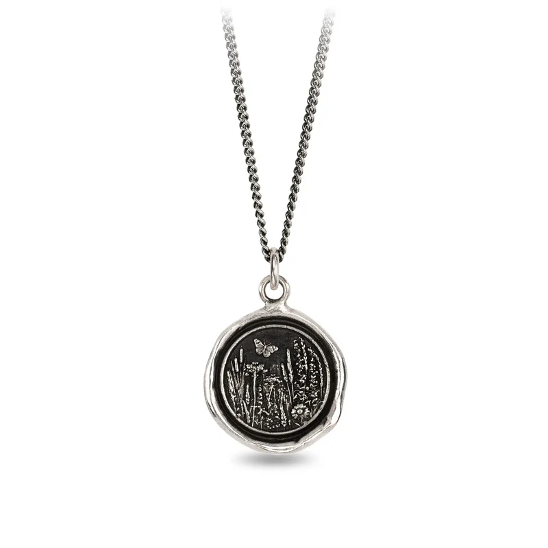 Sterling Silver Necklace with a talisman depicting a Butterfly above a large field of flowers and plants.