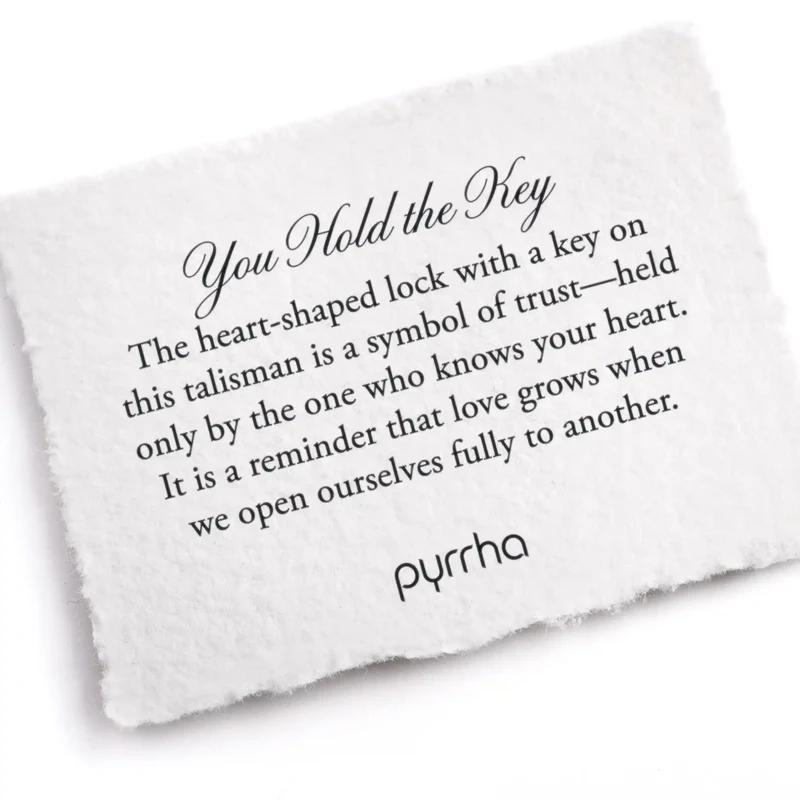 A Pyrrha note describing the You Hold the Key talisman. It reads, "The heart-shaped lock with a key on this talisman is a symbol of trust—held only by the one who knows your heart. It is a reminder that love grows when we open ourselves fully to another."