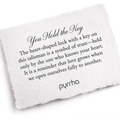 A Pyrrha note describing the You Hold the Key talisman. It reads, "The heart-shaped lock with a key on this talisman is a symbol of trust—held only by the one who knows your heart. It is a reminder that love grows when we open ourselves fully to another."