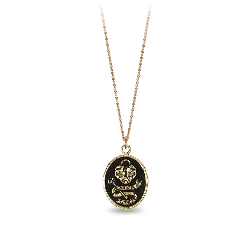 14k Yellow gold talisman necklace depicting a Large lock in the shape on a heart above a key with a ribbon that says "You Hold The key"
