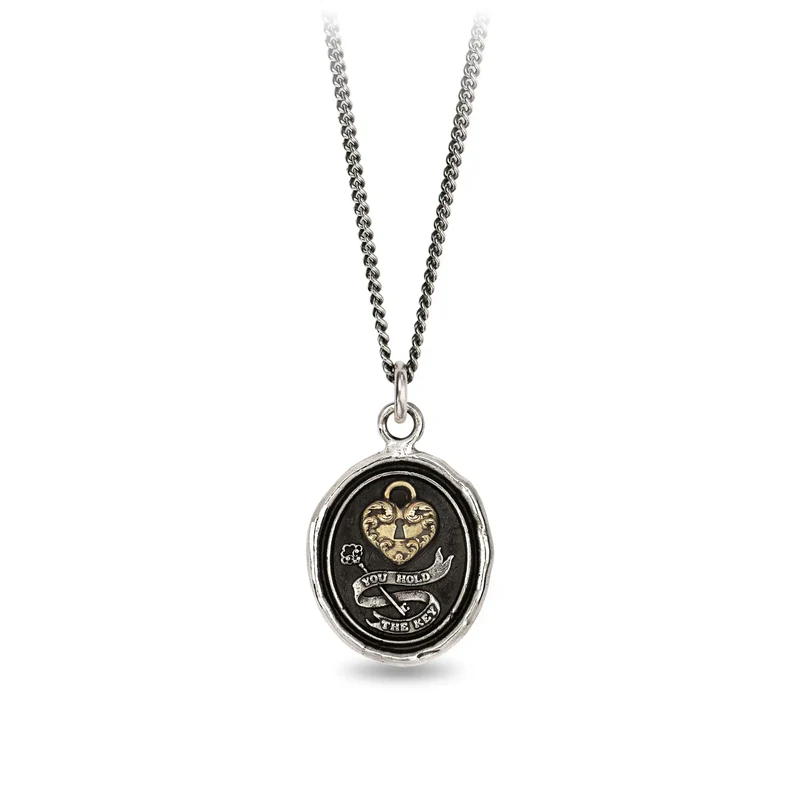 A Sterling Silver talisman necklace with a gold Plated heart lock, above a silver key surrounded by the words "You Hold the Key" on a banner