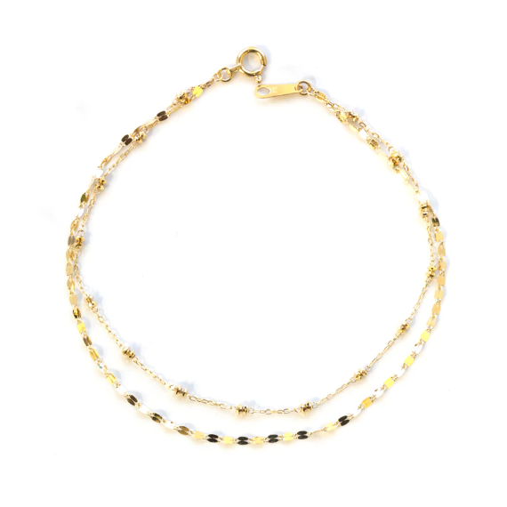 This 18-karat gold bracelet features two distinctive strands—one adorned with faceted gold beads and the other with small diamond-cut discs