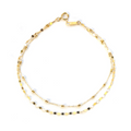 This 18-karat gold bracelet features two distinctive strands—one adorned with faceted gold beads and the other with small diamond-cut discs