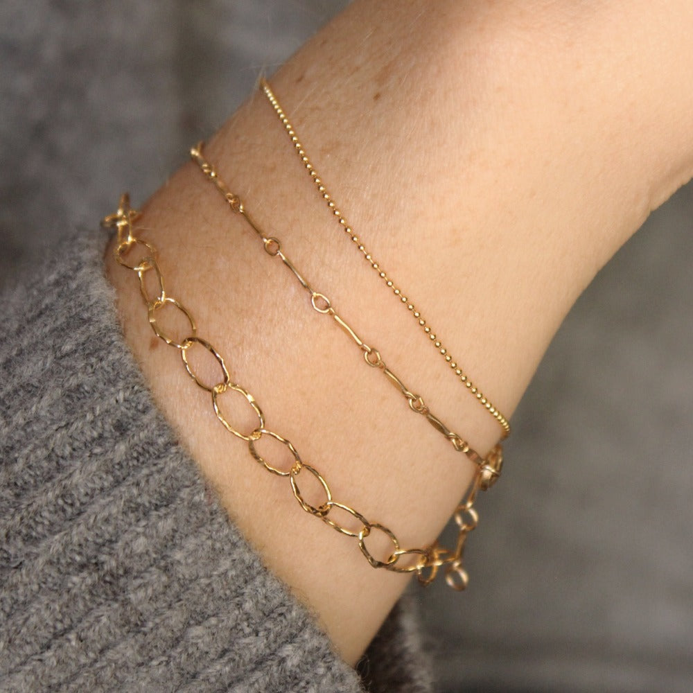 Hammered Oval Link Bracelet | Magpie Jewellery | Yellow Gold | On Model | Layered with Dapped Bar and Tiny Ball Chain Bracelets, Left-to-Right