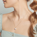 A large baroque pearl pendant anchors a 14-karat gold chain with a trio of baby keshi pearl on one side. | on model