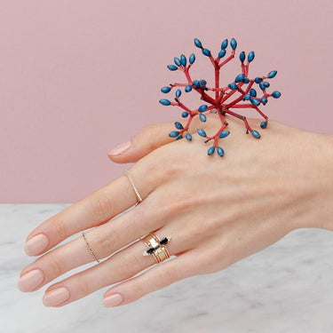 14-karat gold ring showcasing a prong-set oval-shaped Sapphire with three light-catching diamonds. Set at the top of a slim gold band for an adornment | on model