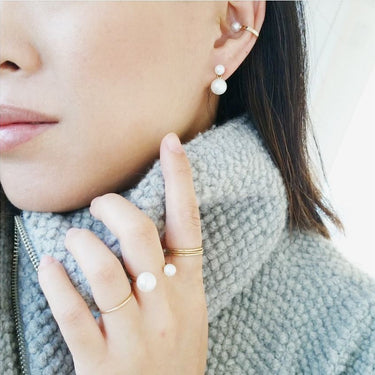 A pair of double pearl 14k Gold earrings featuring four lustrous pearls | on model