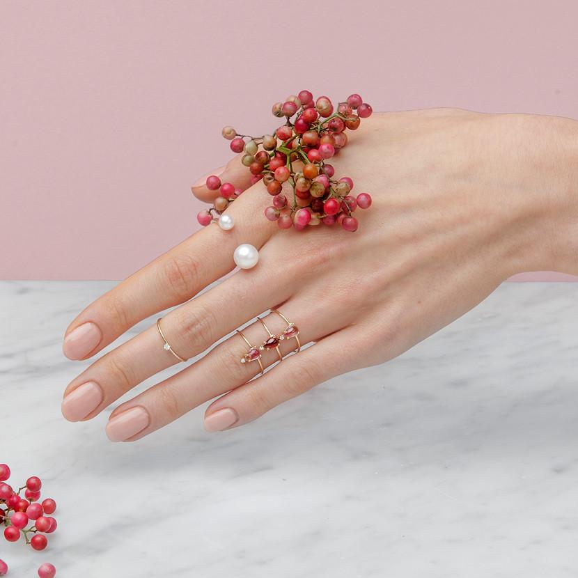 14-karat gold ring showcasing a beautiful pear-shaped garnet with a diamond at the tip. |on model