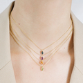 A vibrant marquise cut gemstone pendant on a dainty 14-karat gold cable chain | on model