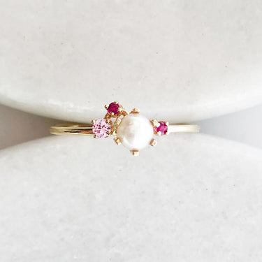 14K Yellow Gold cluster ring showcasing a white pearl at its center, adorned by Two Rubys and a pink sapphire 