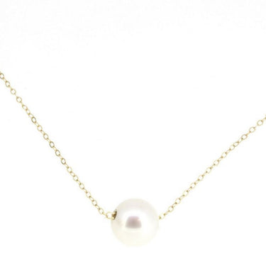 A single luscious round white pearl on a delicate 14-karat shimmering gold chain