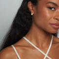 A pull through earring style featuring a pair of lustrous petite oval shaped pearls | on model