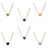 A vibrant heart shaped gemstone pendant on a dainty 14-karat gold chain. 