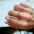 Three gradient colored blue topaz arranged from dark to light on a delicate solid 14-karat gold band.  | on model