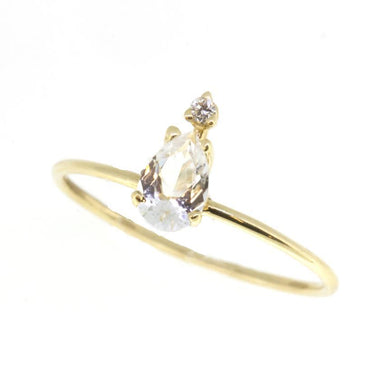  14-karat gold, ring showcasing a beautiful light-catching pear-shaped white topaz with a diamond at the tip.