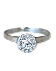14kt white gold ring with a round brilliant diamond with a halo of diamonds and a textured finish