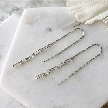 Silver chain threader earrings displayed on marble. The earrings are compose of five narrow links, the first of which is attached to a long piece of fine box chain with an earring post at one end.  | Magpie Jewellery